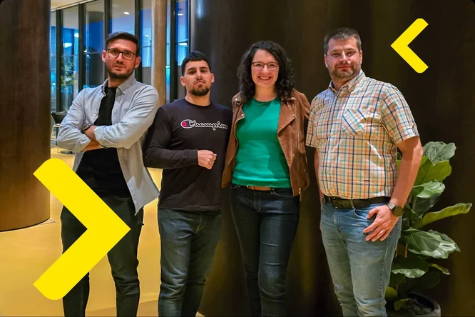 Four people standing in front of a yellow arrow, ready to embark on an exciting journey together