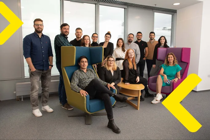 A diverse group of individuals sitting in a room, attentively following yellow arrows. Collaboration and focus in action!